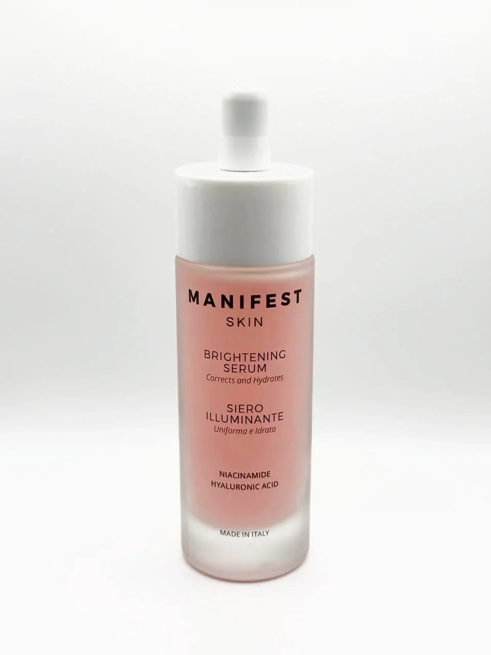 Siero illuminante Manifest Skin con niacinamide e acido ialuronico su fondo bianco, skincare Buzz Skin